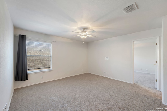 unfurnished room with carpet, visible vents, ceiling fan, and baseboards