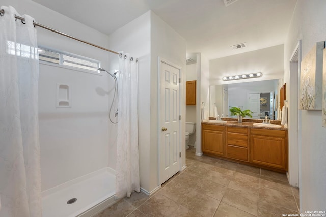 full bathroom featuring a shower with shower curtain, visible vents, a sink, and toilet