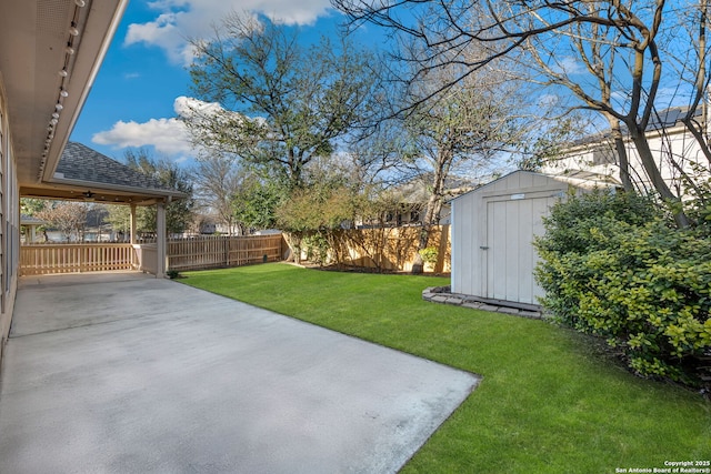 view of yard with a shed, fence, a patio, and an outdoor structure