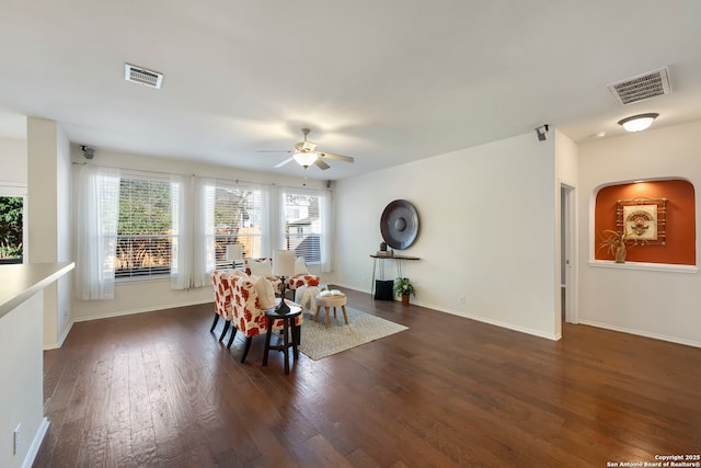 dining space with a ceiling fan, baseboards, visible vents, and dark wood-type flooring