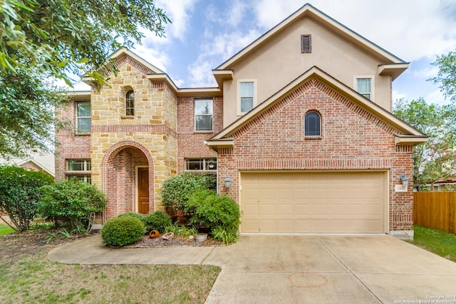 view of front of property with a garage, driveway, brick siding, and fence