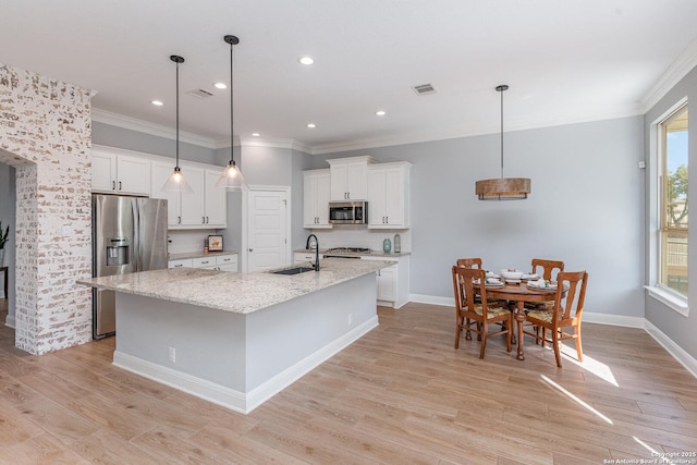 kitchen with light wood-style flooring, a sink, visible vents, white cabinetry, and appliances with stainless steel finishes