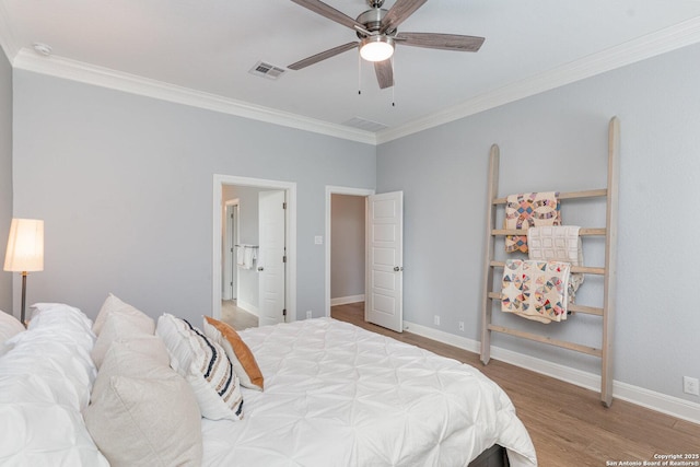 bedroom featuring ornamental molding, visible vents, baseboards, and wood finished floors