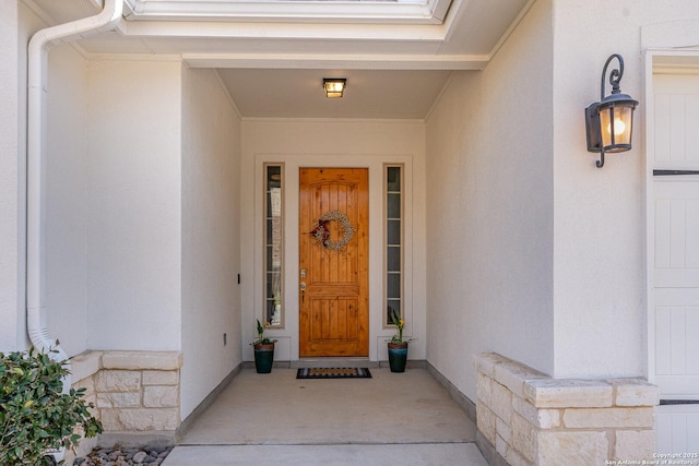 entrance to property featuring stone siding and stucco siding