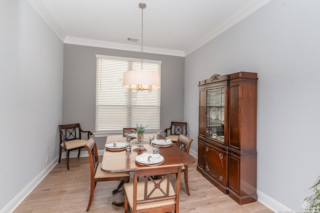 dining space featuring light wood-style floors, baseboards, and crown molding