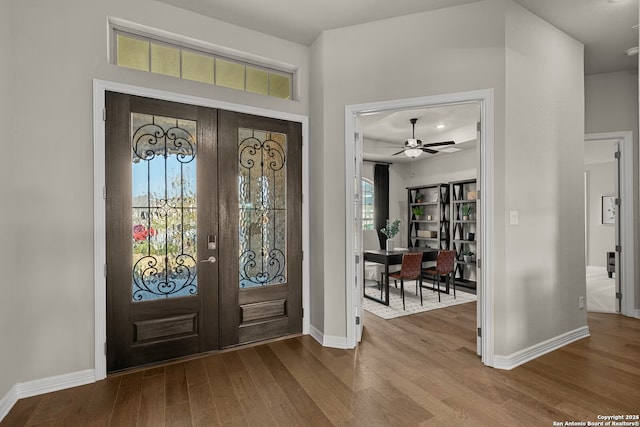 foyer featuring baseboards, dark wood finished floors, and french doors