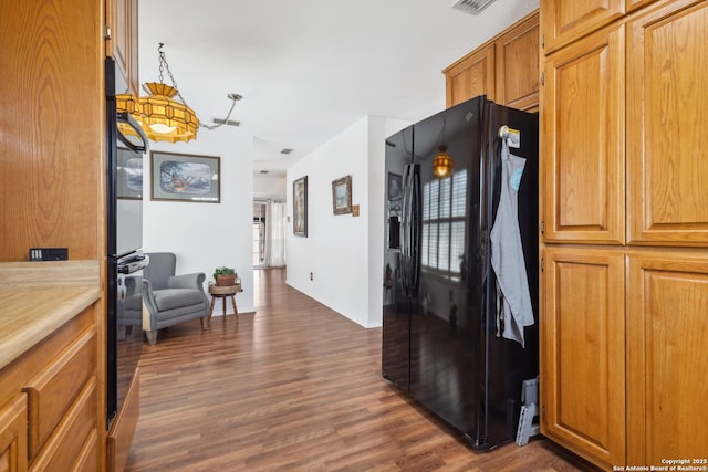 corridor featuring wood finished floors and visible vents