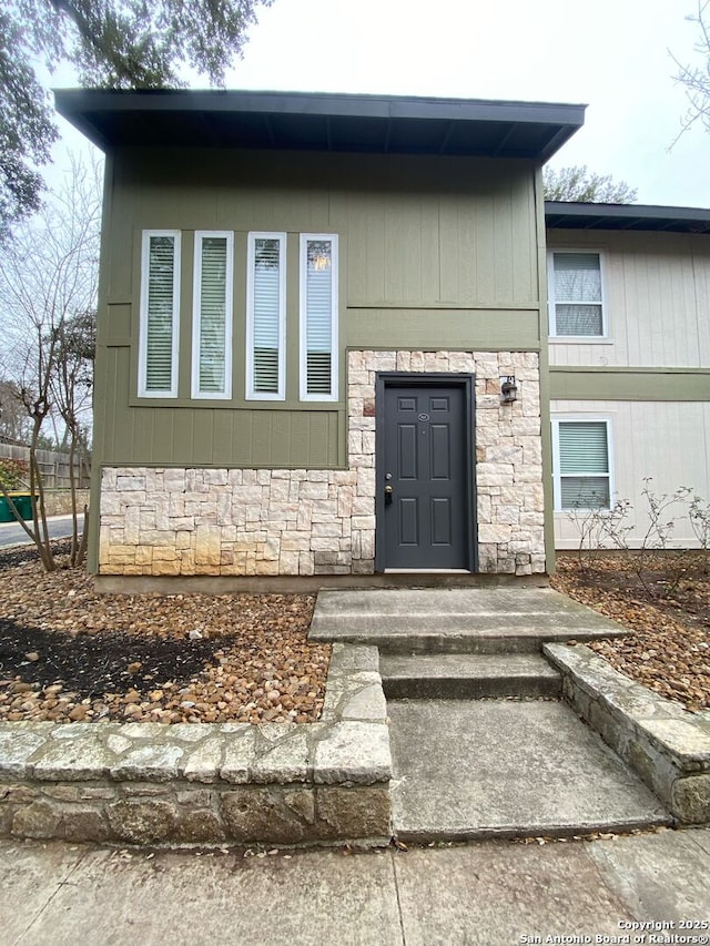 property entrance featuring stone siding