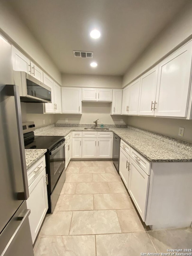 kitchen with appliances with stainless steel finishes, visible vents, a sink, and white cabinetry