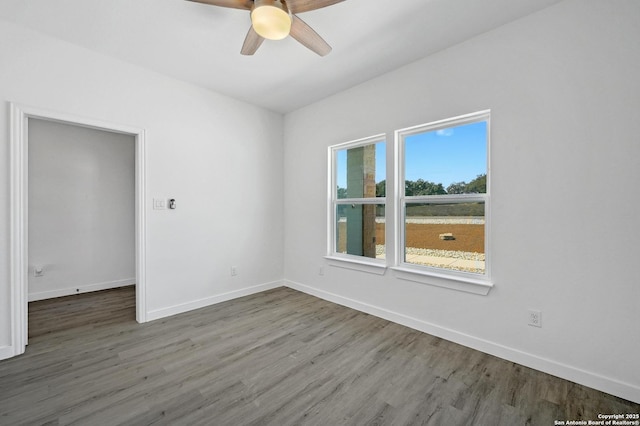 empty room featuring ceiling fan, wood finished floors, and baseboards