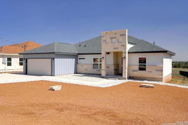 view of front of home with a shingled roof, concrete driveway, fence, a garage, and stone siding