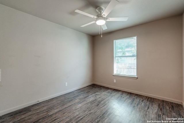 empty room with ceiling fan, wood finished floors, and baseboards