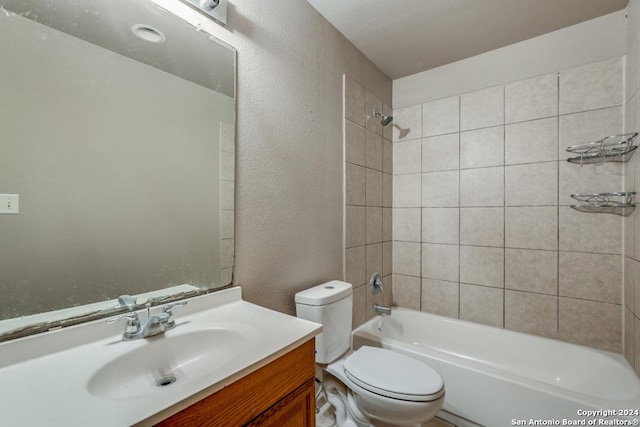 bathroom featuring a textured wall, vanity, toilet, and bathing tub / shower combination