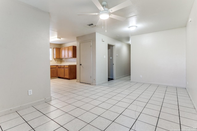 unfurnished living room featuring a ceiling fan, visible vents, and baseboards