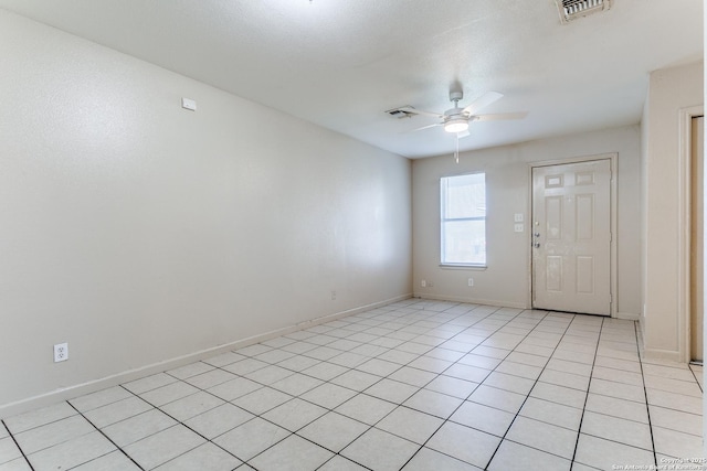 unfurnished room with a ceiling fan, visible vents, baseboards, and light tile patterned floors