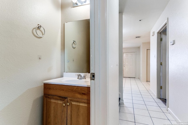 bathroom with tile patterned flooring, visible vents, vanity, and baseboards