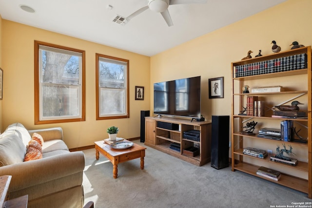 living room featuring carpet floors, visible vents, baseboards, and a ceiling fan