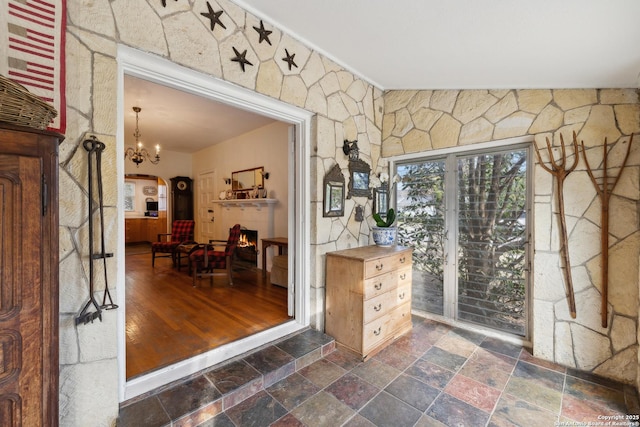 interior space with stone tile floors, arched walkways, and a chandelier