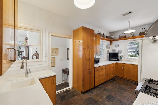 kitchen featuring black microwave, a sink, visible vents, light countertops, and stone finish floor