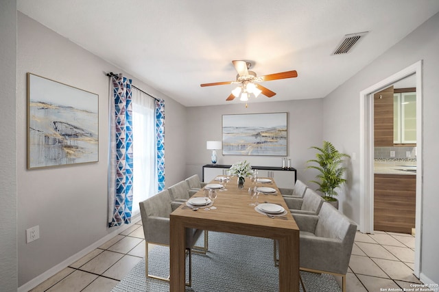 dining area featuring light tile patterned floors, baseboards, visible vents, and a ceiling fan