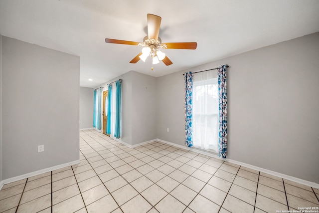 spare room featuring baseboards, a ceiling fan, and light tile patterned flooring