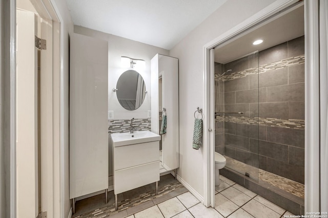 full bathroom with backsplash, toilet, a tile shower, vanity, and tile patterned floors