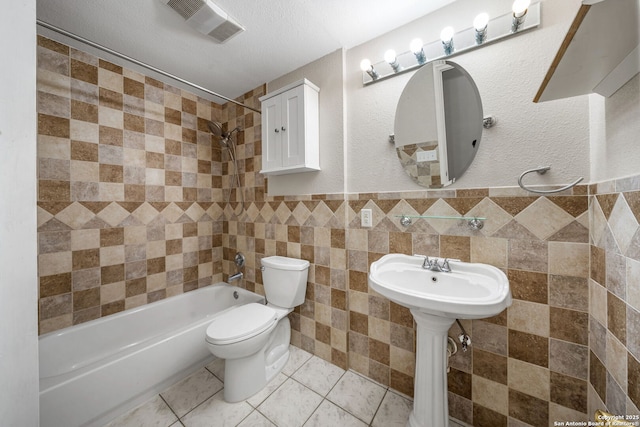 full bath featuring visible vents, toilet, tile patterned floors, bathtub / shower combination, and tile walls