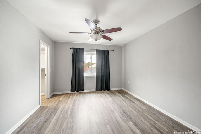 unfurnished room featuring light wood-type flooring, ceiling fan, and baseboards