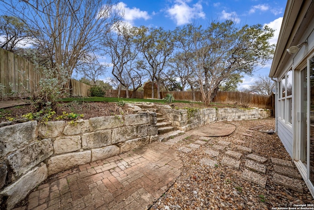 view of yard with a fenced backyard, a shed, a patio, and an outbuilding