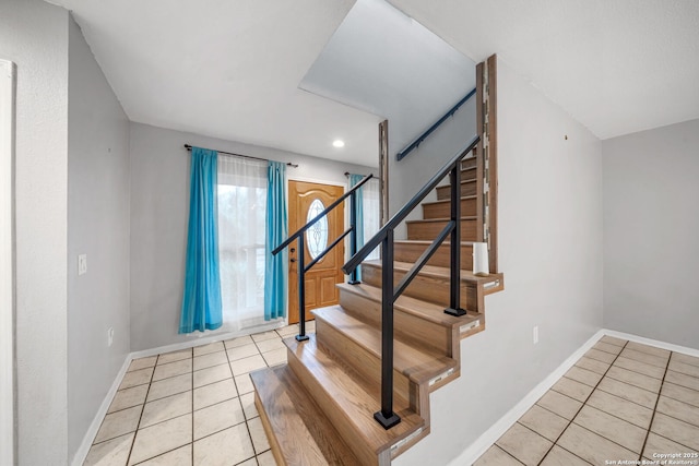 foyer with stairway, baseboards, and light tile patterned floors