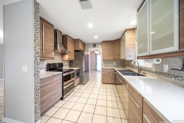 kitchen with light tile patterned floors, a sink, visible vents, appliances with stainless steel finishes, and wall chimney range hood