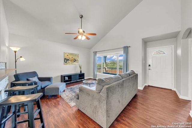 living area featuring ceiling fan, high vaulted ceiling, wood finished floors, and baseboards