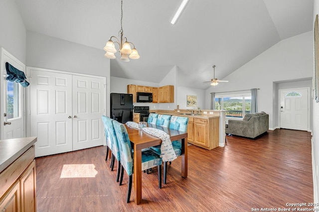 dining area with ceiling fan with notable chandelier, high vaulted ceiling, dark wood-style flooring, and baseboards