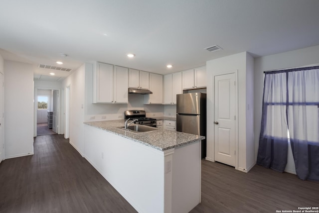 kitchen with under cabinet range hood, a sink, visible vents, white cabinets, and dark wood-style floors