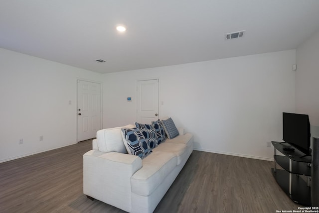 living room featuring baseboards, visible vents, and wood finished floors