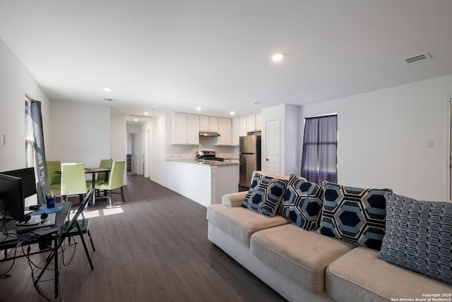 living room with visible vents, dark wood-type flooring, and recessed lighting