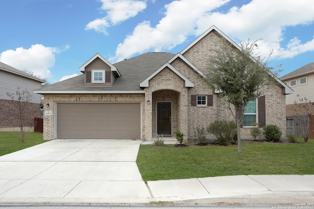 view of front of property with brick siding, an attached garage, fence, driveway, and a front lawn