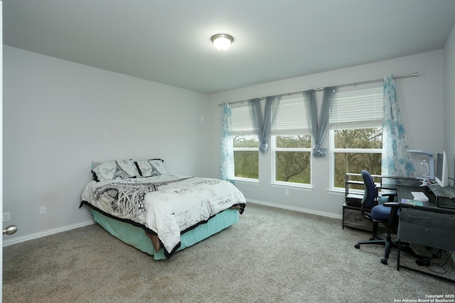 carpeted bedroom featuring multiple windows and baseboards