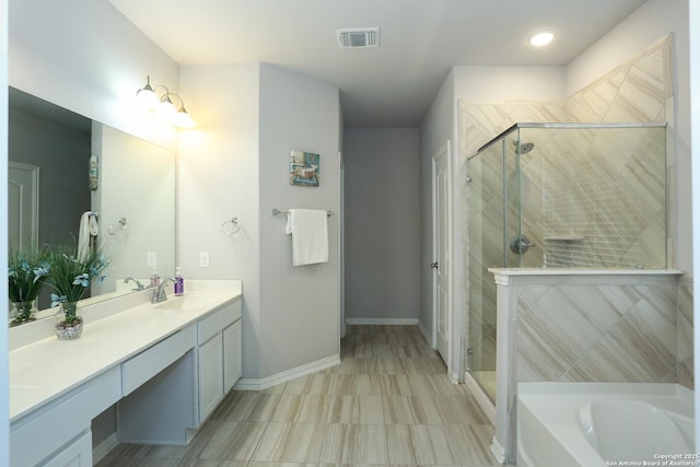 bathroom featuring a garden tub, visible vents, a stall shower, vanity, and baseboards