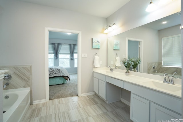 full bathroom featuring double vanity, a bathtub, a sink, and ensuite bathroom