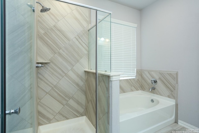 bathroom featuring a garden tub and a shower stall