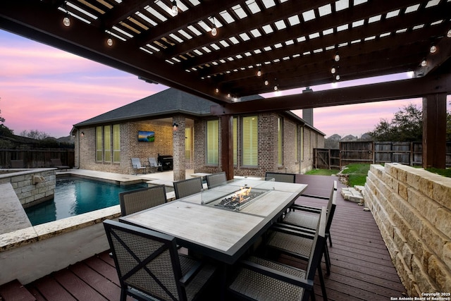 deck at dusk featuring an outdoor fire pit, a fenced in pool, a fenced backyard, a pergola, and outdoor dining space