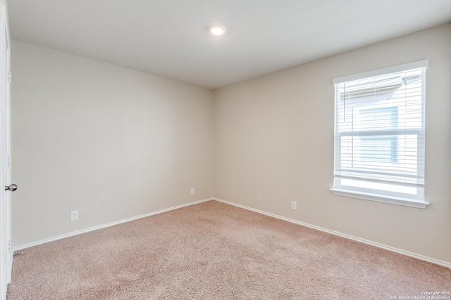 empty room featuring baseboards and carpet flooring