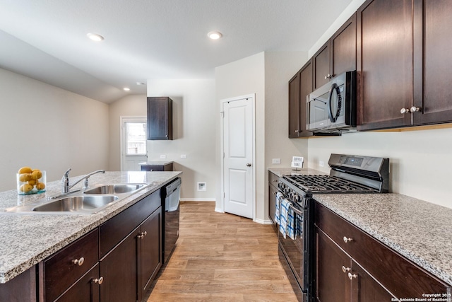 kitchen with dark brown cabinetry, a sink, baseboards, light wood-style floors, and appliances with stainless steel finishes