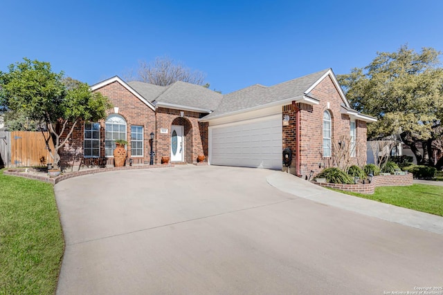 view of front of property with concrete driveway, brick siding, a front lawn, and an attached garage