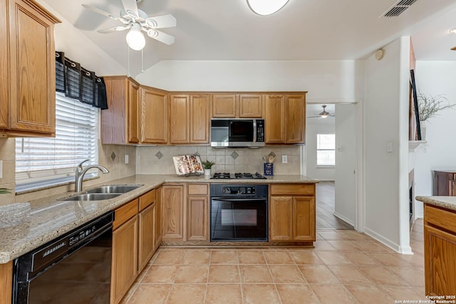 kitchen with tasteful backsplash, visible vents, ceiling fan, black appliances, and a sink