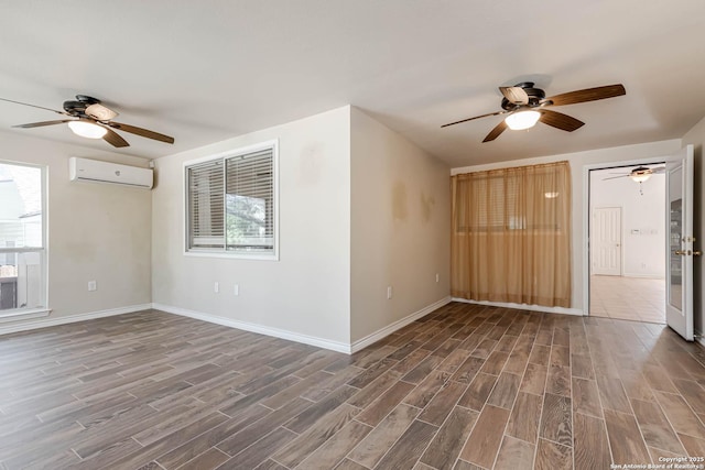 empty room featuring an AC wall unit, baseboards, and wood finished floors