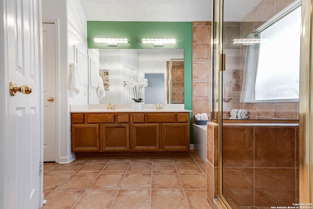 full bath with double vanity, a stall shower, a sink, and tile patterned floors