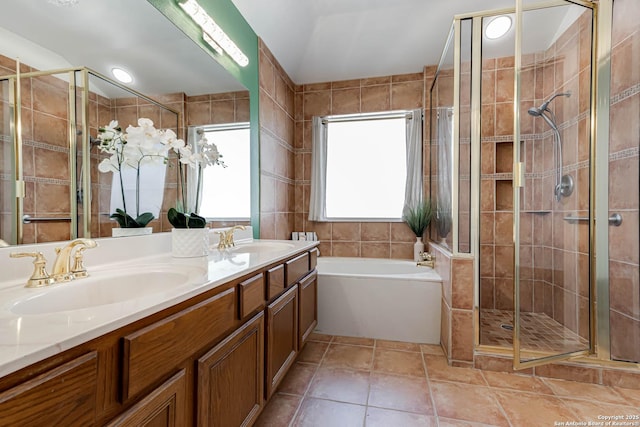 bathroom featuring a bath, a stall shower, and a sink