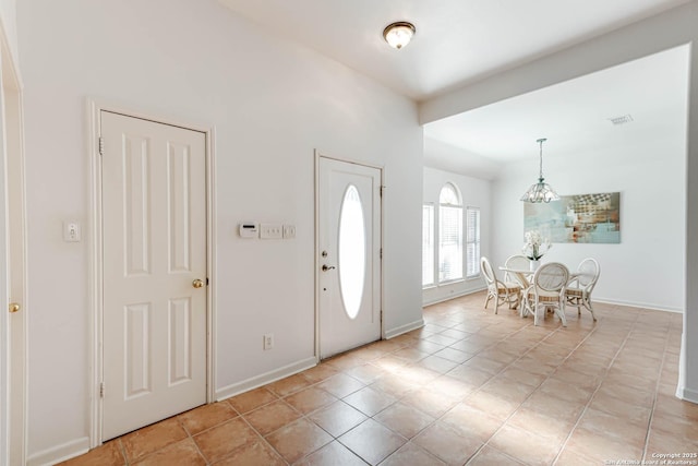 entrance foyer featuring light tile patterned floors, visible vents, and baseboards